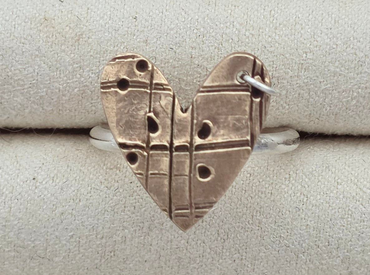 Silver heart-shaped pendant on a light gray background